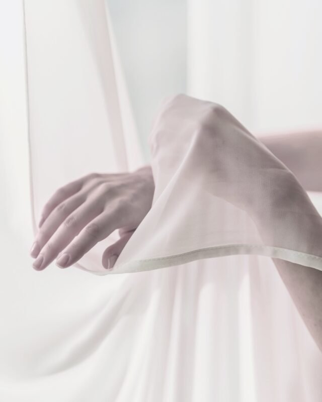 Sanfte Bewegung für Frauen: Frauenhände gleiten durch fließenden Stoff – Qigong mit DancingQi